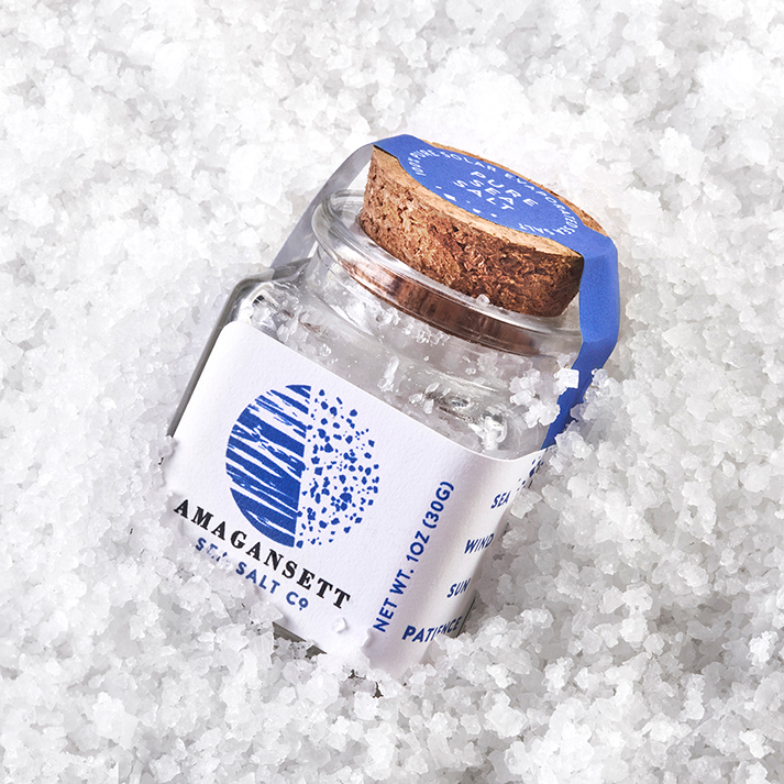 Glass jar of natural, solar evaporated finishg salt on a bed of Amagansett Sea Salt